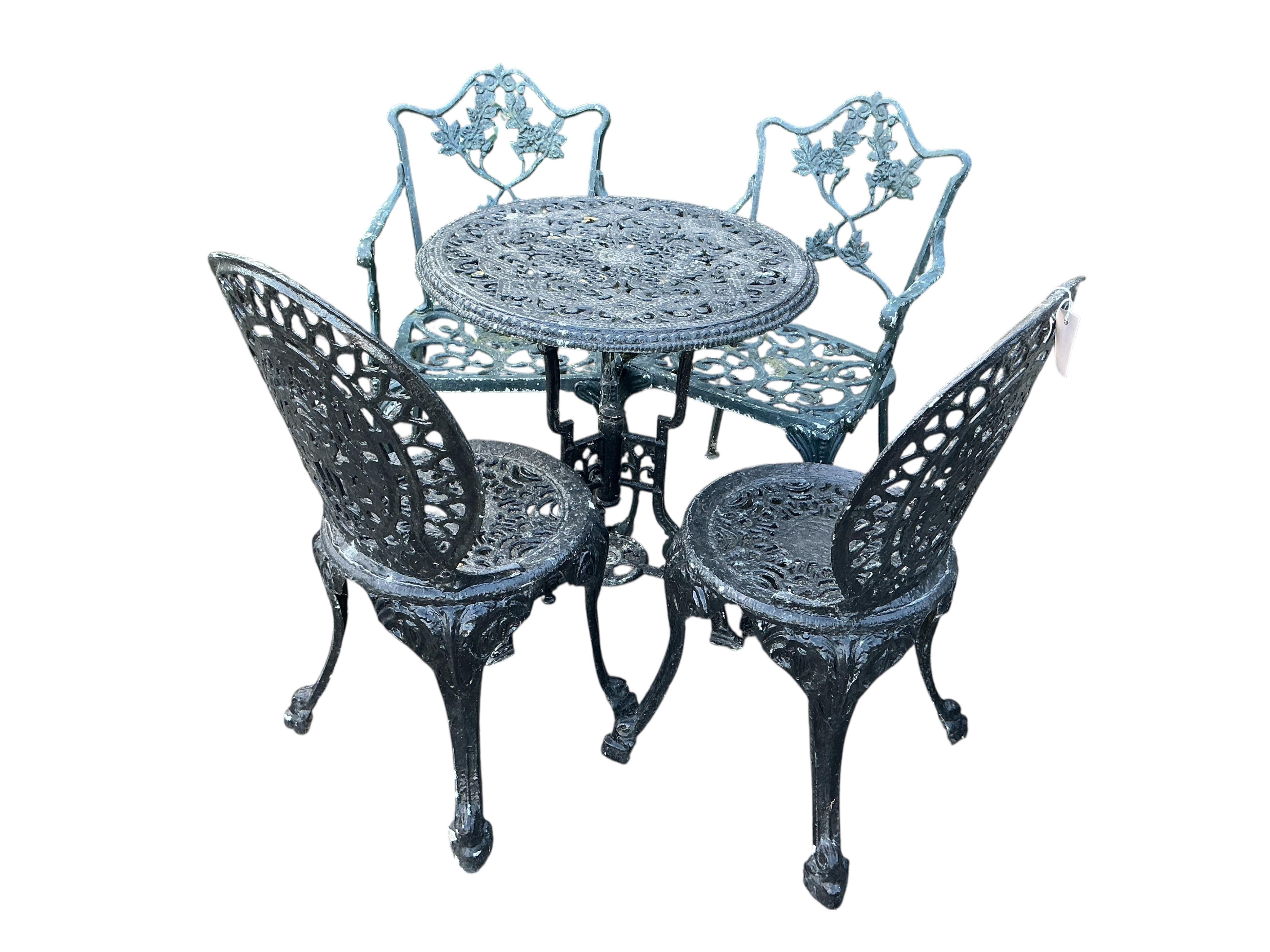 A Victorian style circular aluminium garden table, diameter 60cm together with two pairs of chairs